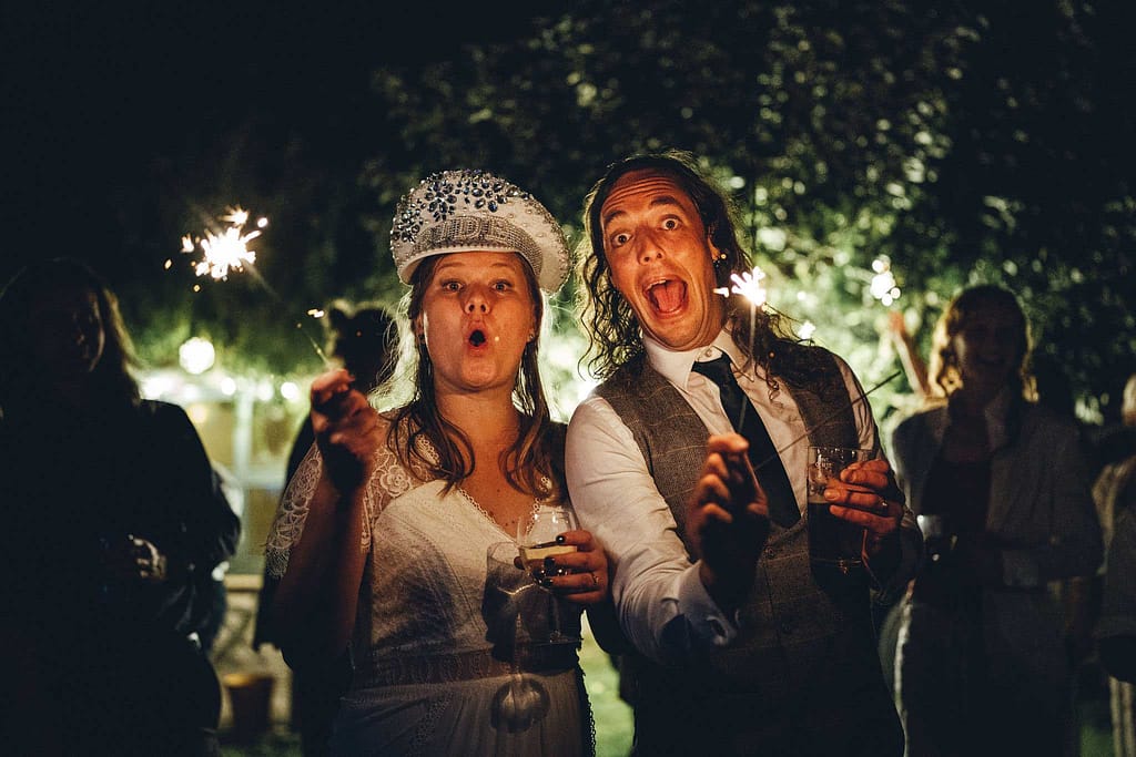 Bride and groom with sparklers at festival wedding
